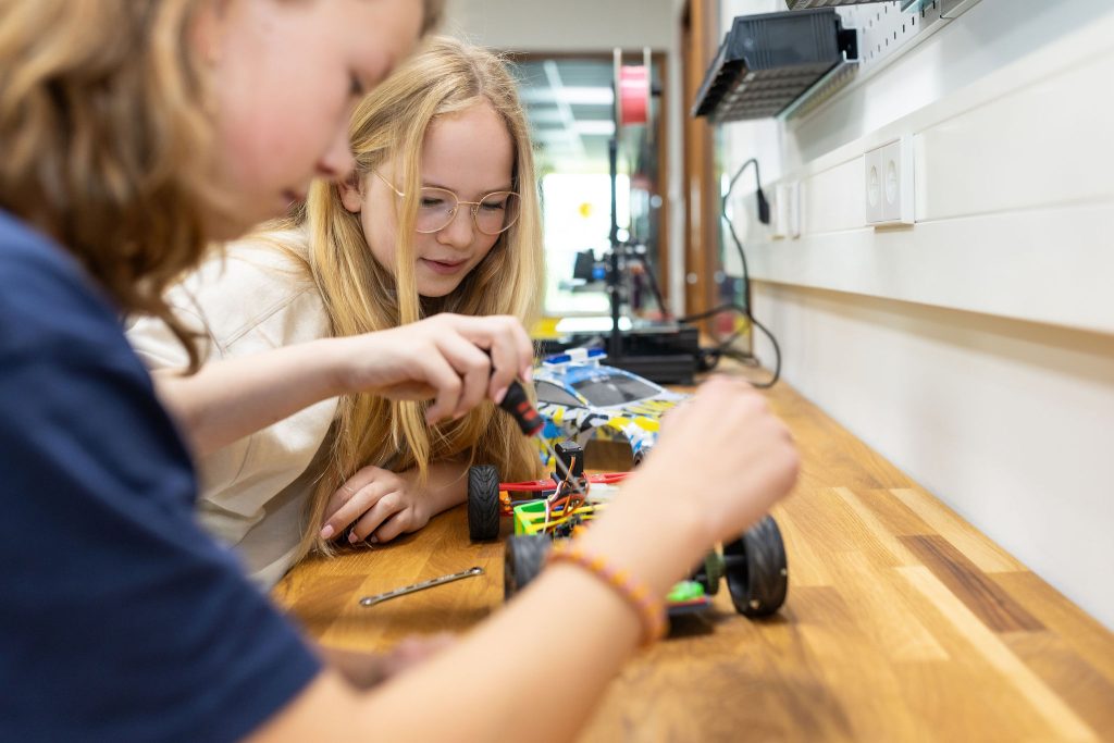 Leerlingen werken samen aan een technisch project in het praktijklokaal van het Stedelijk College.